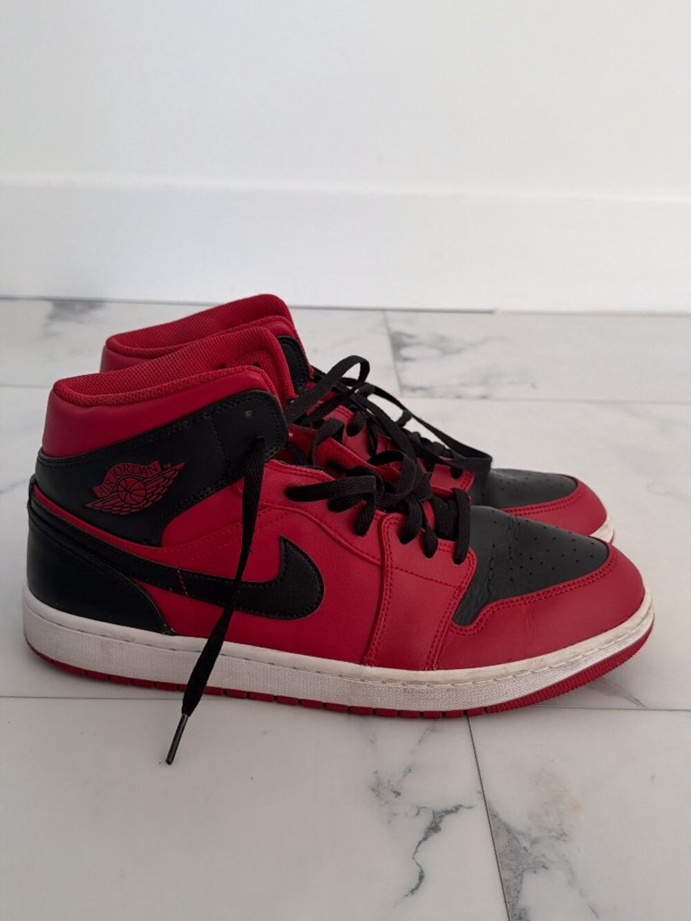 Authentic Nike Air Jordan 1 Mid Reverse Bred sneakers.
